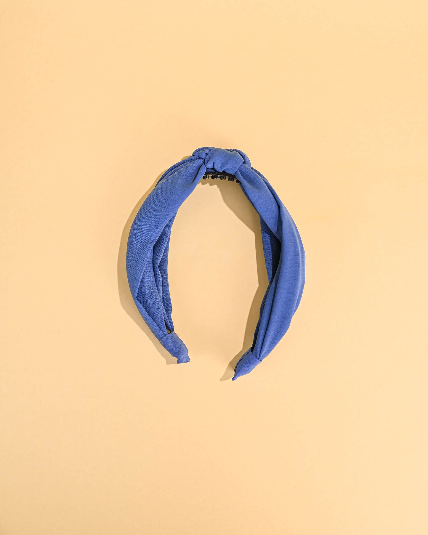 Blue top knot headband showcased on a plain background.