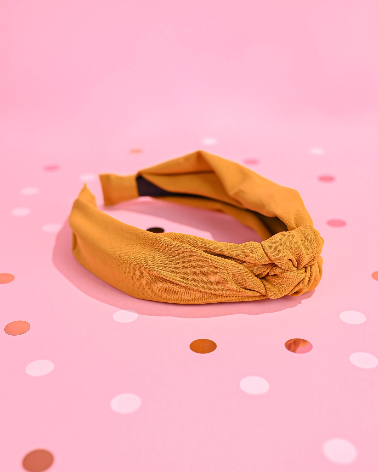 yellow top knot headband at an angle, with polka dots in the backdrop.