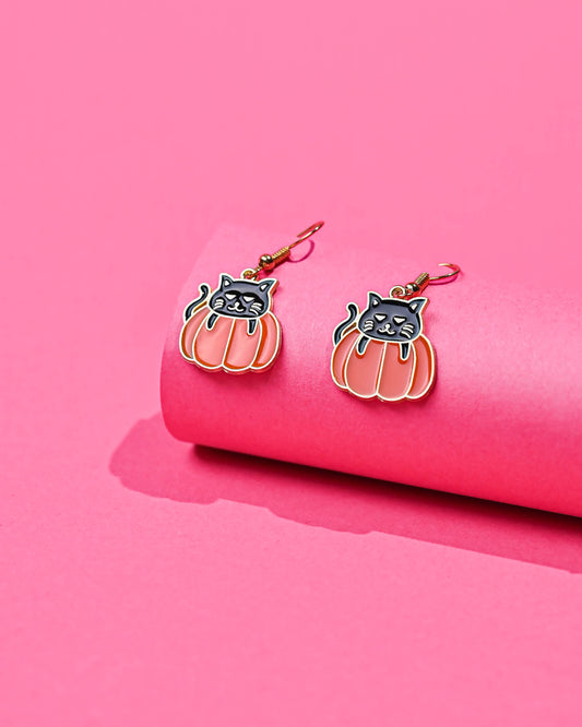 Elegant Black Cat Dangle Earrings with cats perched on pumpkins against a vibrant pink backdrop.