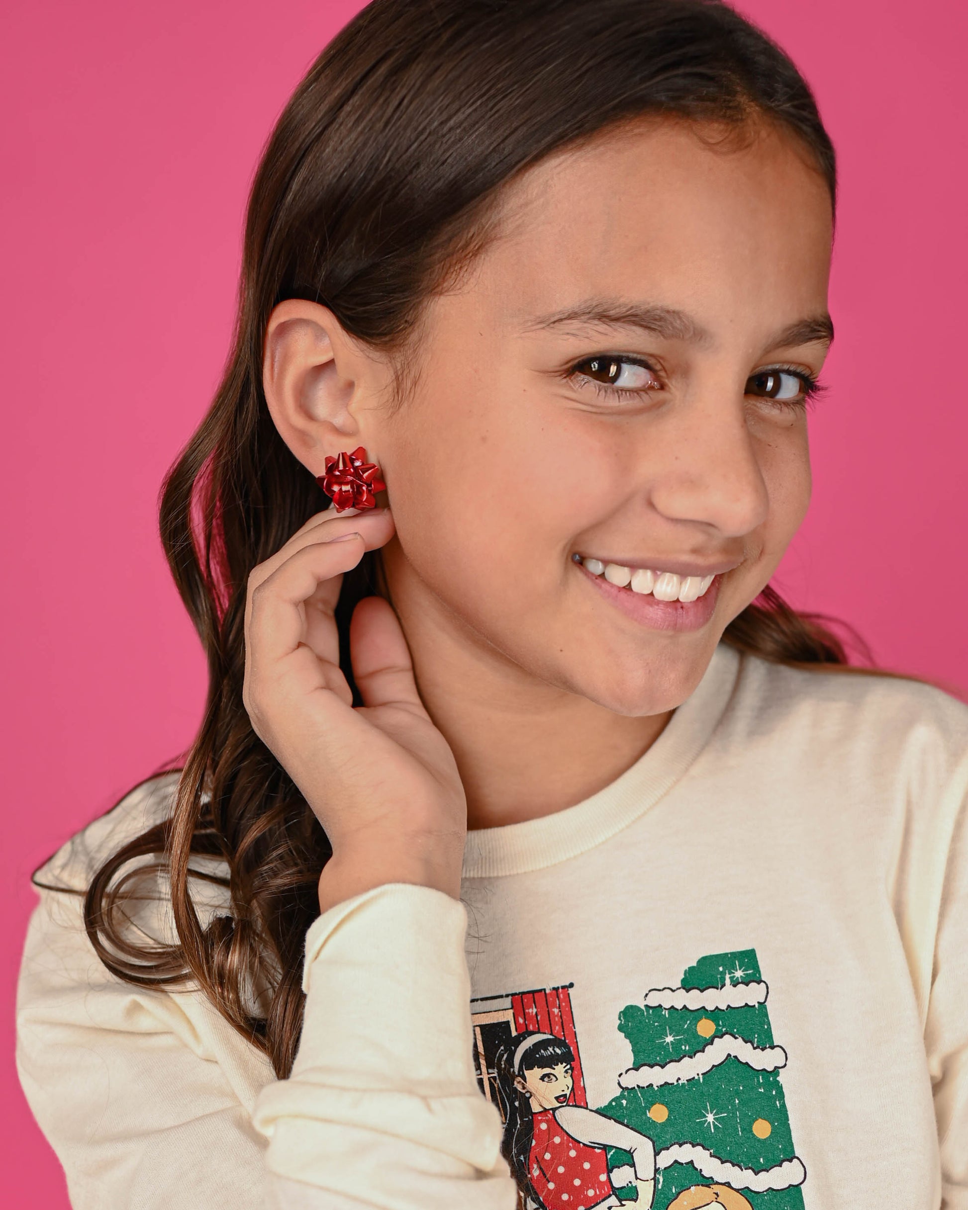 Smiling girl wearing red Bow Earrings, adding a festive touch to her holiday-themed outfit.